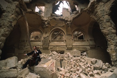 Vedran Smailović playing cello in the ruins of the Sarajevo library; photo by Mikhail Evstafiev
